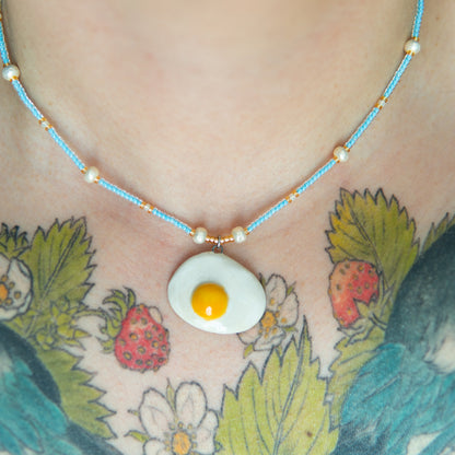 Oeuf au plat - collier élastique, pendentif en céramique